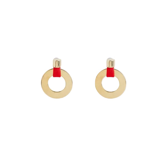 A pair of gold hoop earrings with a small red fabric accent at the top, shown on a clean white background.