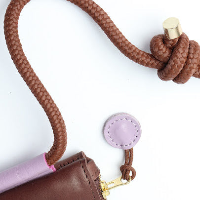 Brown braided keychain with pink pouch on a white background