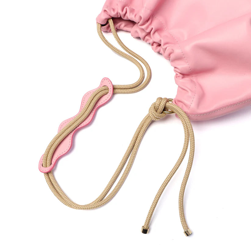 Pink drawstring bag with beige drawstring on a white background
