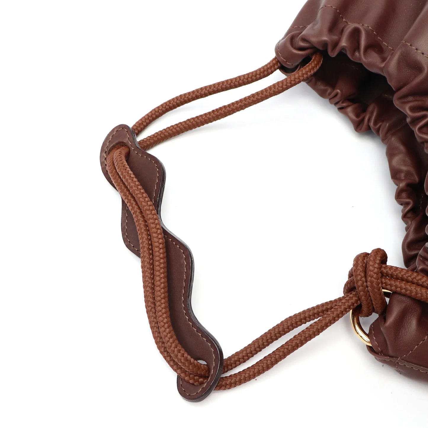 Close-up of a brown drawstring gather style closure bag with braided handle on a white background