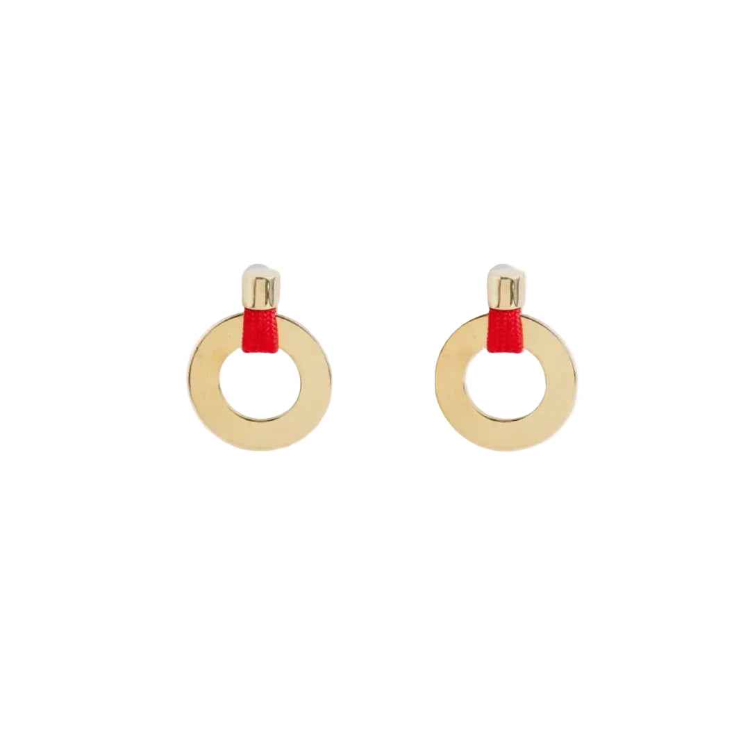 A pair of gold hoop earrings with a small red fabric accent at the top, shown on a clean white background.