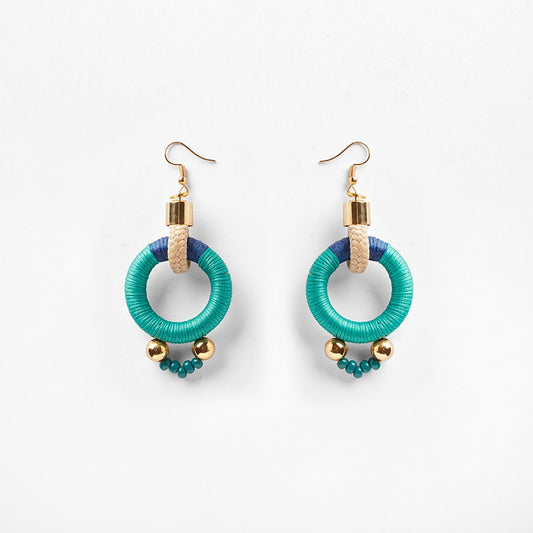 Circular blue and aqua rope earrings featuring a sleek s-hook clasp for secure fastening. The vibrant colors of blue and aqua intertwine beautifully, creating a striking visual contrast. Delicate beads embellish the bottom of the earrings, accented with shimmering gold beads that add a touch of elegance. The circular design offers a modern and versatile aesthetic, suitable for various occasions. 
