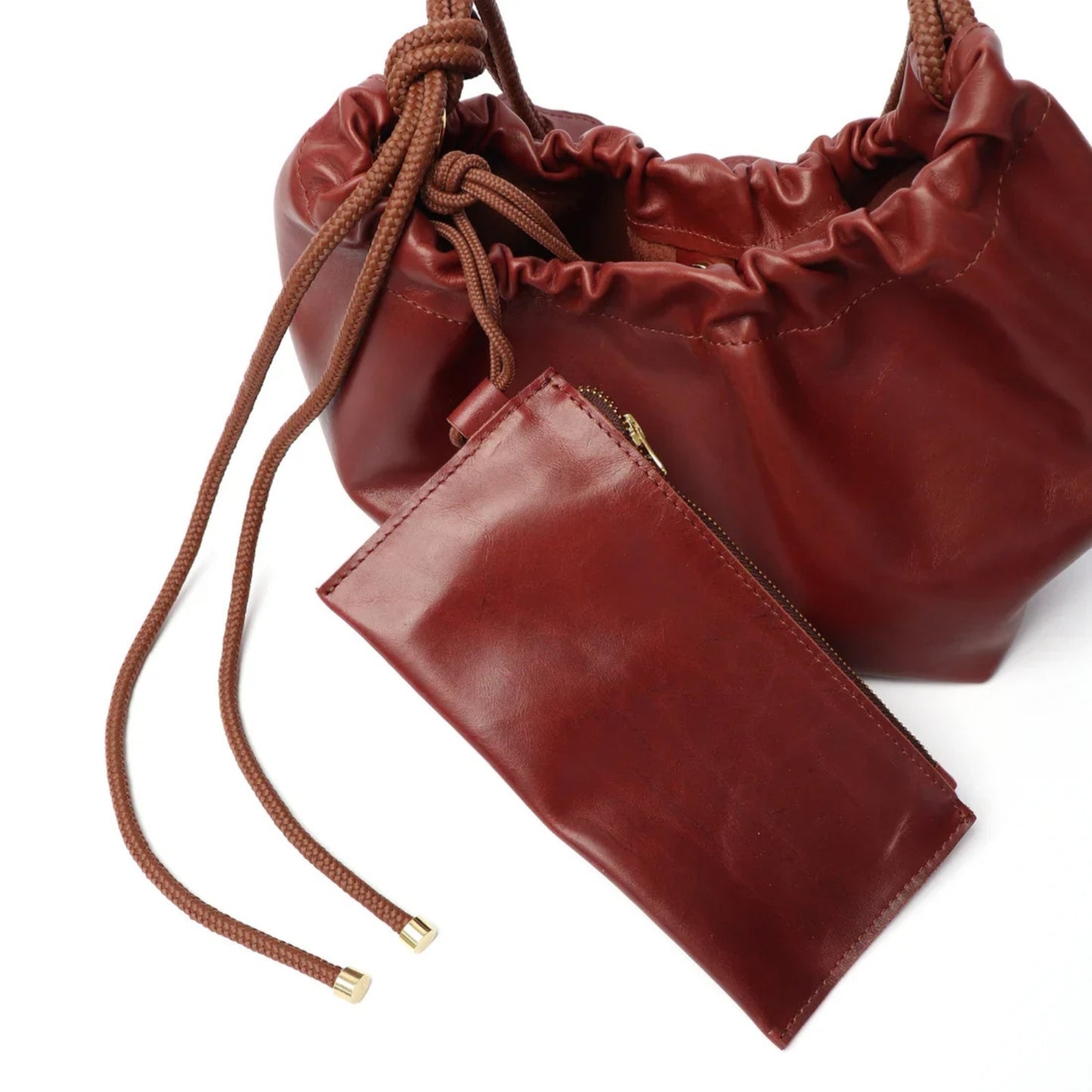 Brown leather drawstring bag with a matching pouch on a white background