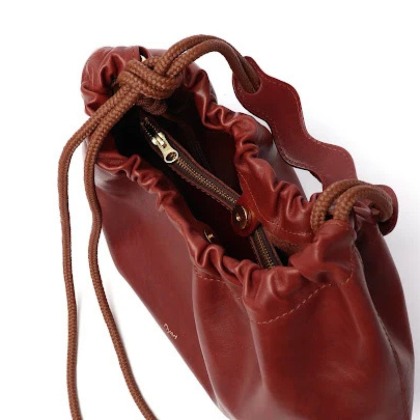 A close-up of a dark reddish-brown leather drawstring pouch bag with a zipper, shown on a white background.