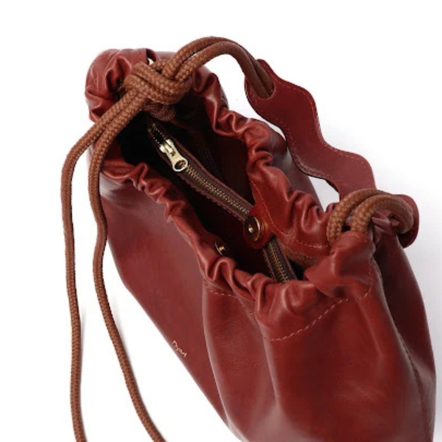 A close-up of a dark reddish-brown leather drawstring pouch bag with a zipper, shown on a white background.