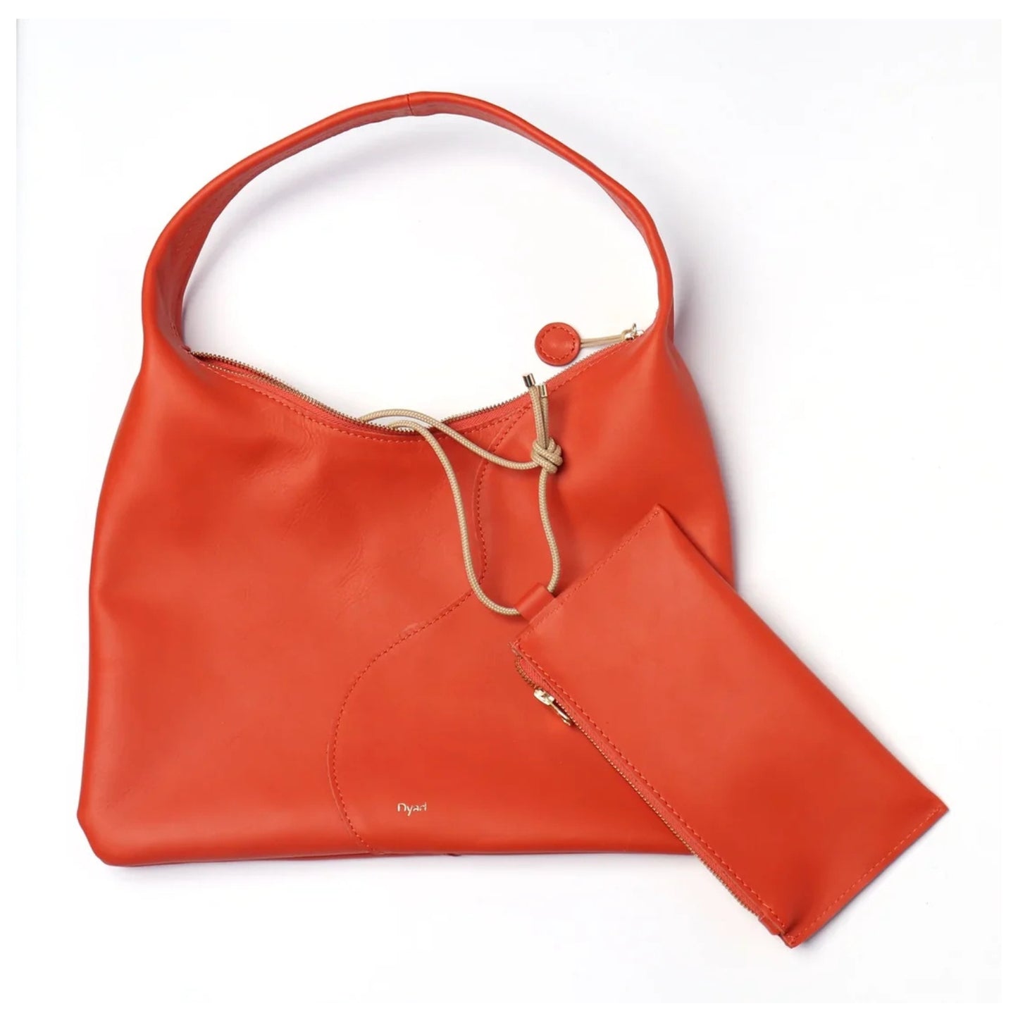 A bright orange-red leather shoulder bag with a matching zippered pouch, displayed on a clean white background.