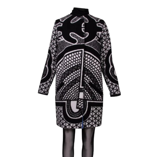 A long-sleeve mock-neck coat featuring a bold black and white geometric and tribal-inspired pattern, displayed on a mannequin against a plain white background.