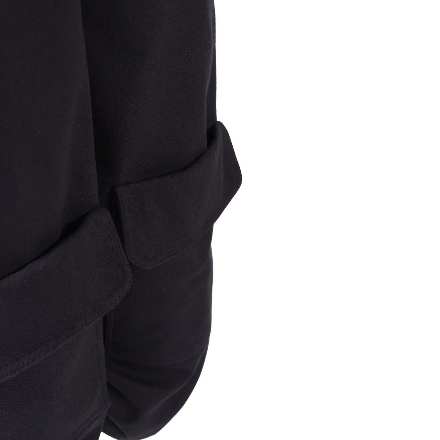 Close-up detail of a black garment legs with a flap pocket, shown against a plain white background.