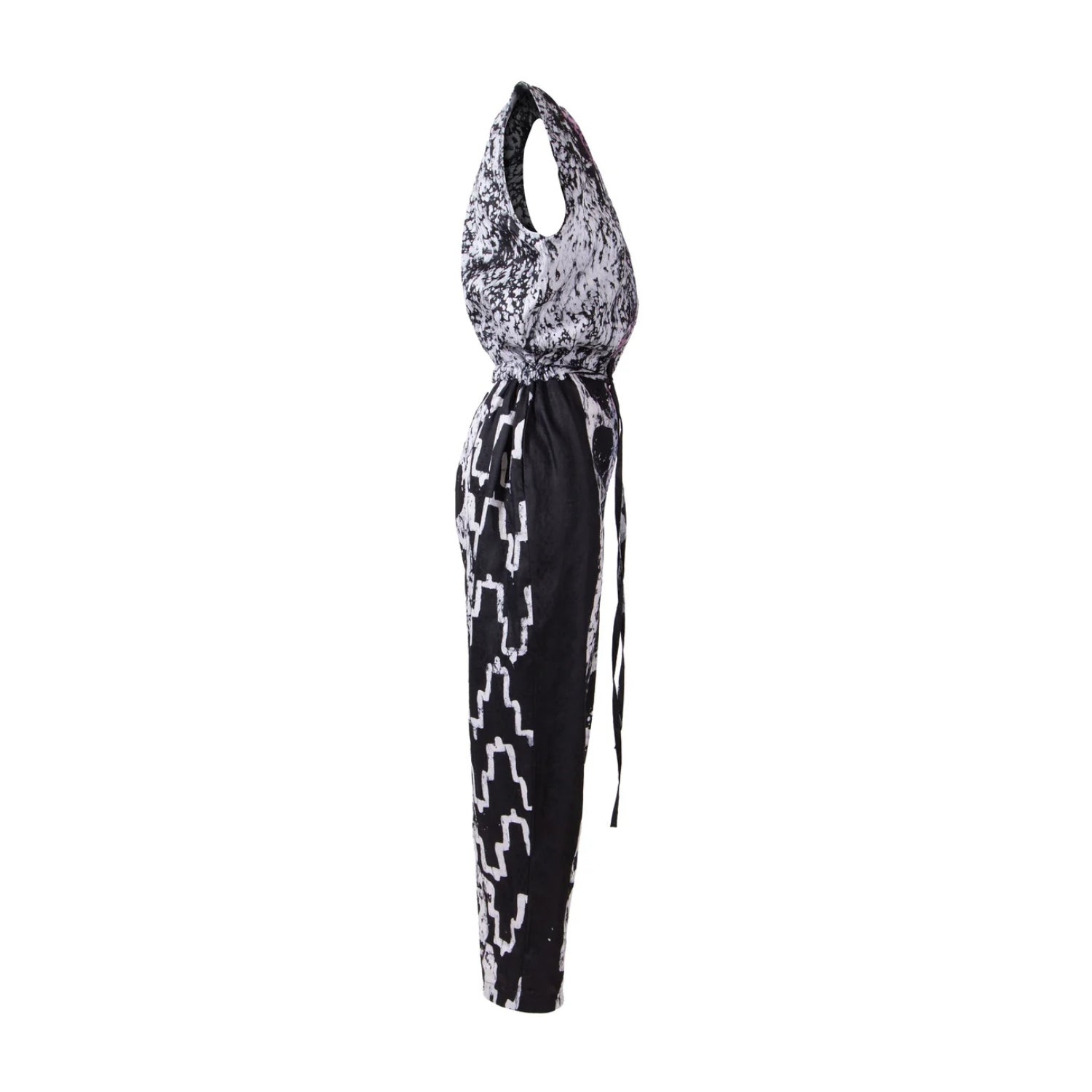 A sleeveless halter-neck jumpsuit with a black and white abstract pattern, featuring a tie-waist detail and geometric print on the legs, shown against a plain white background.