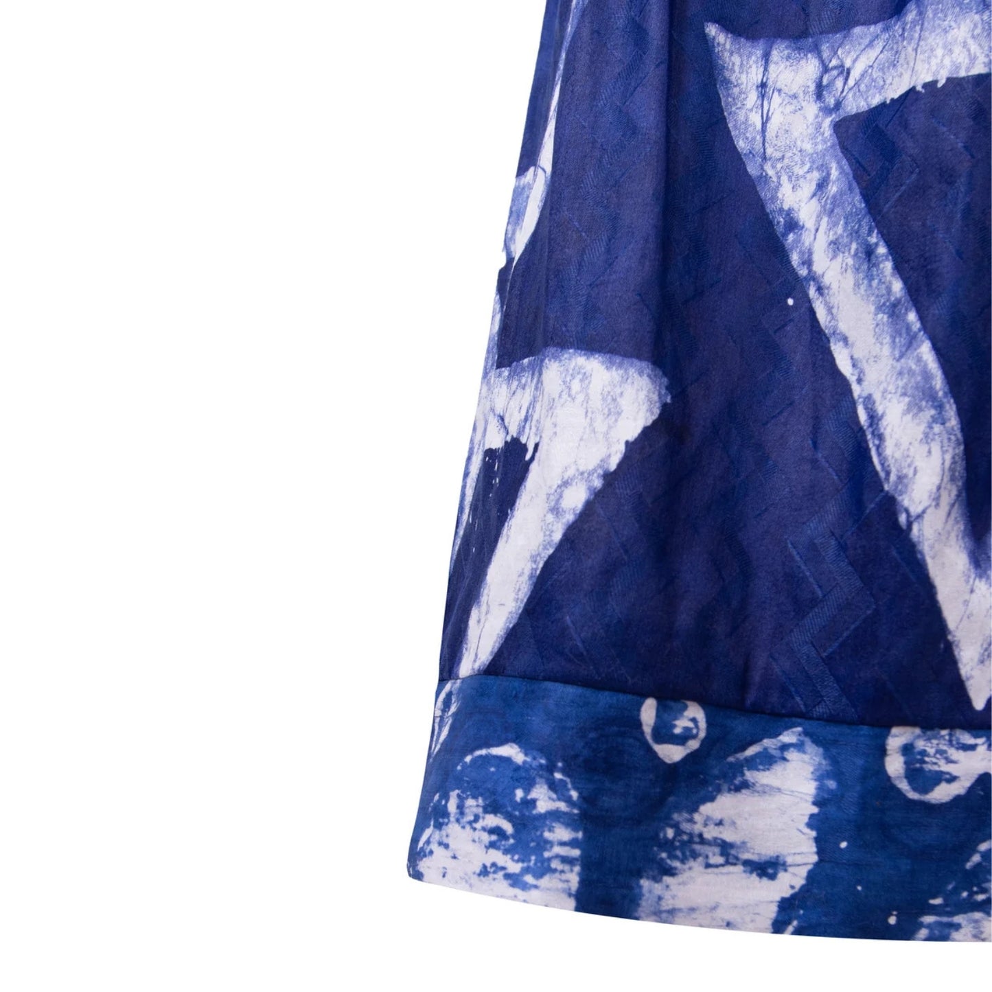 A close-up of a blue and white patterned pants, showing a textured weave and a rolled hem with a matching print, set against a plain white background.