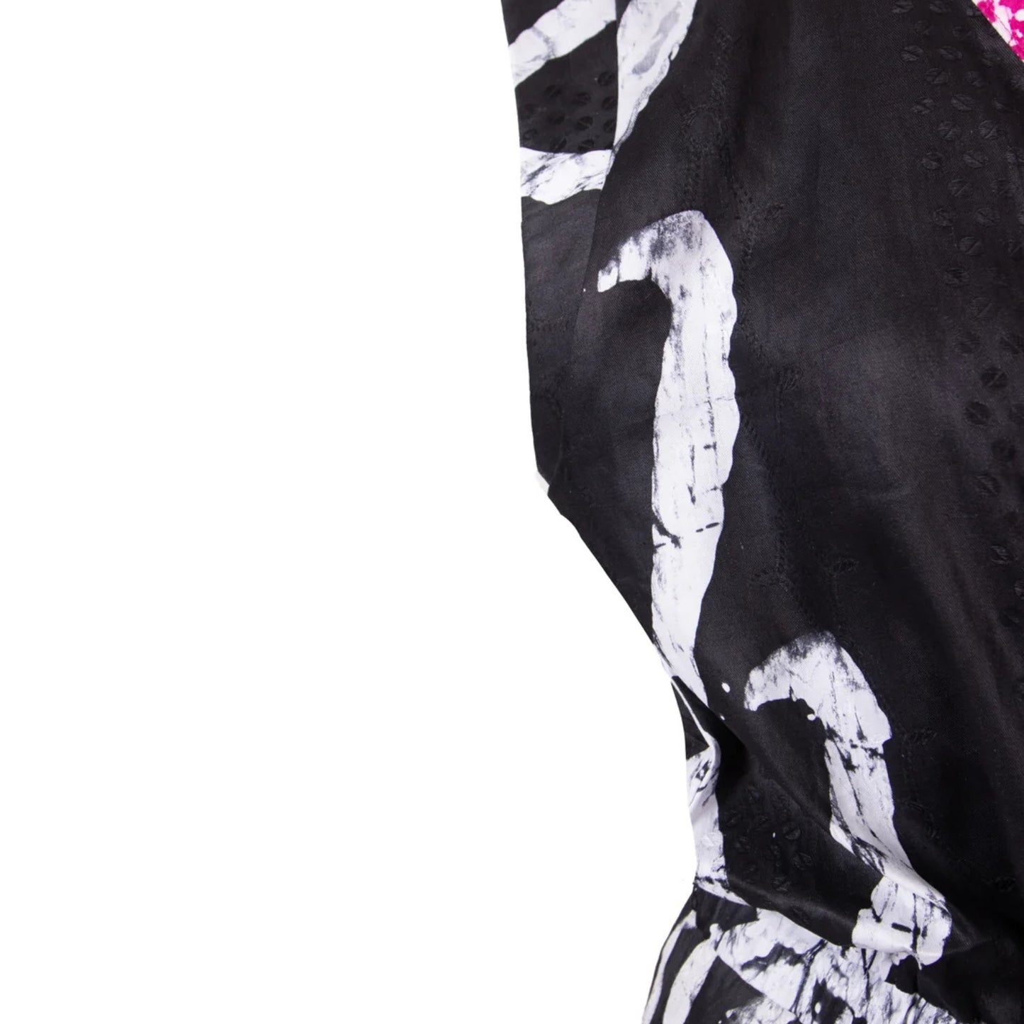 A close-up of a black garment with a bold white abstract brushstroke pattern, shown against a solid white background.