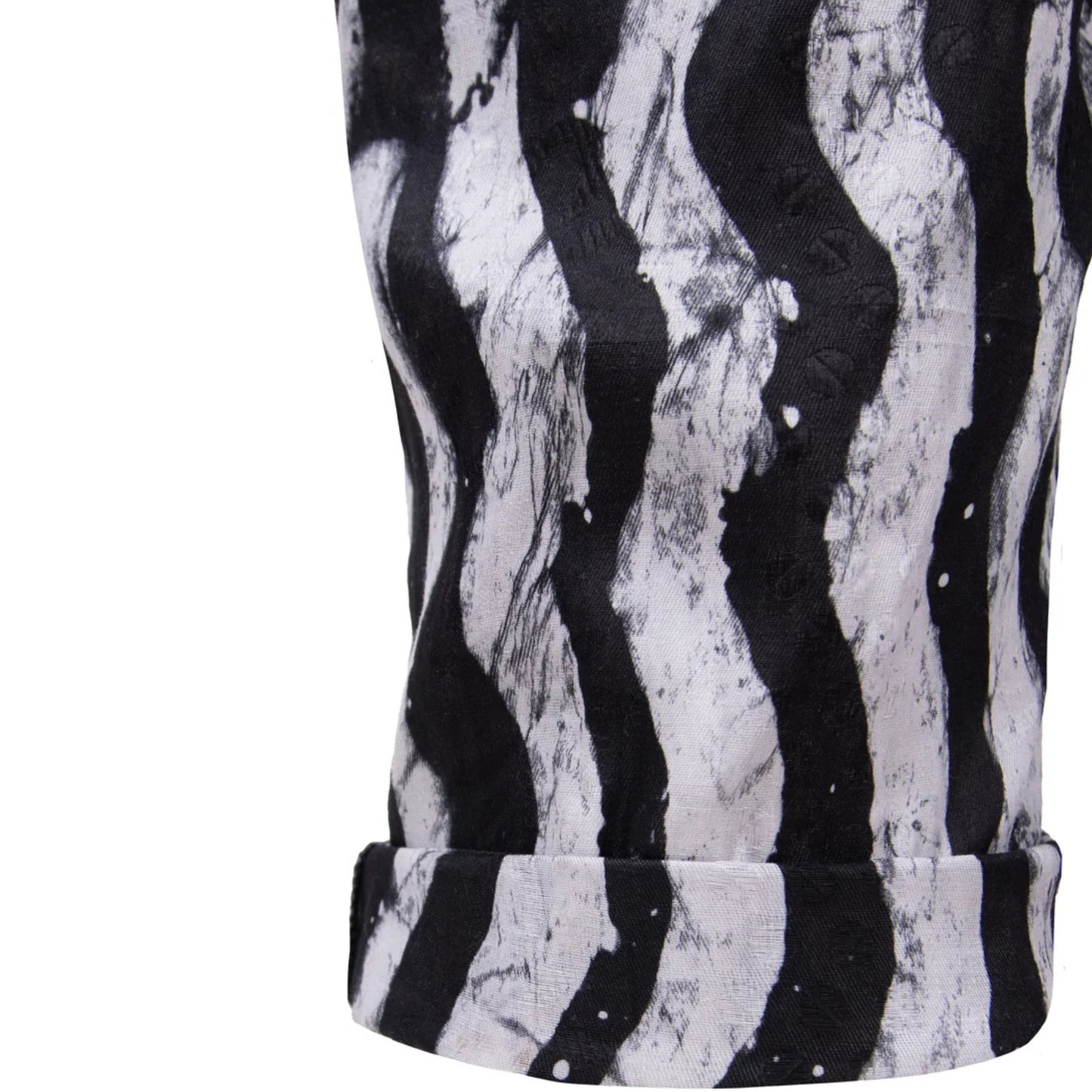 Close-up of a black and white wavy abstract patterned fabric, garment with a rolled leg cuff, on a plain white background.