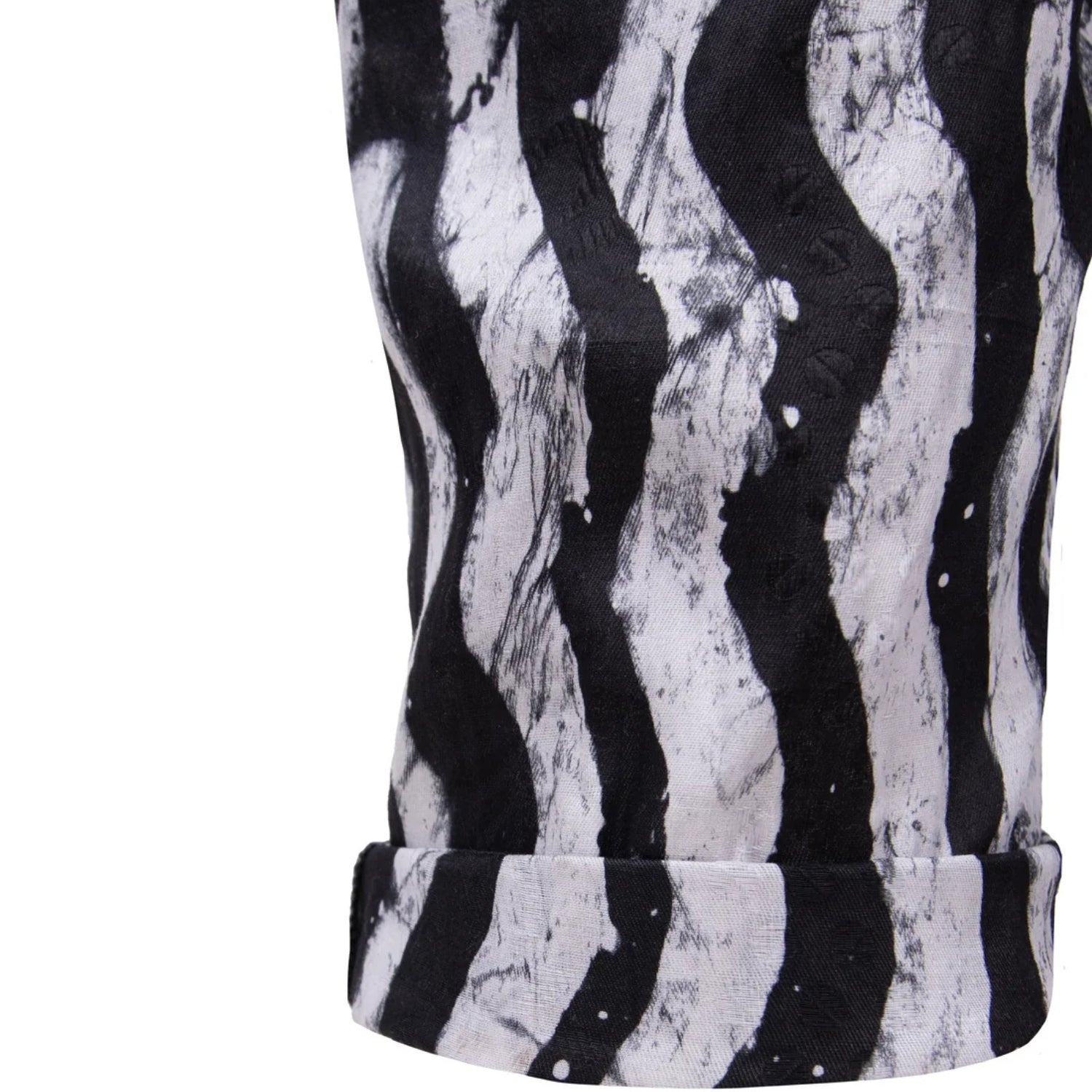 Close-up of a black and white wavy abstract patterned fabric, garment with a rolled leg cuff, on a plain white background.