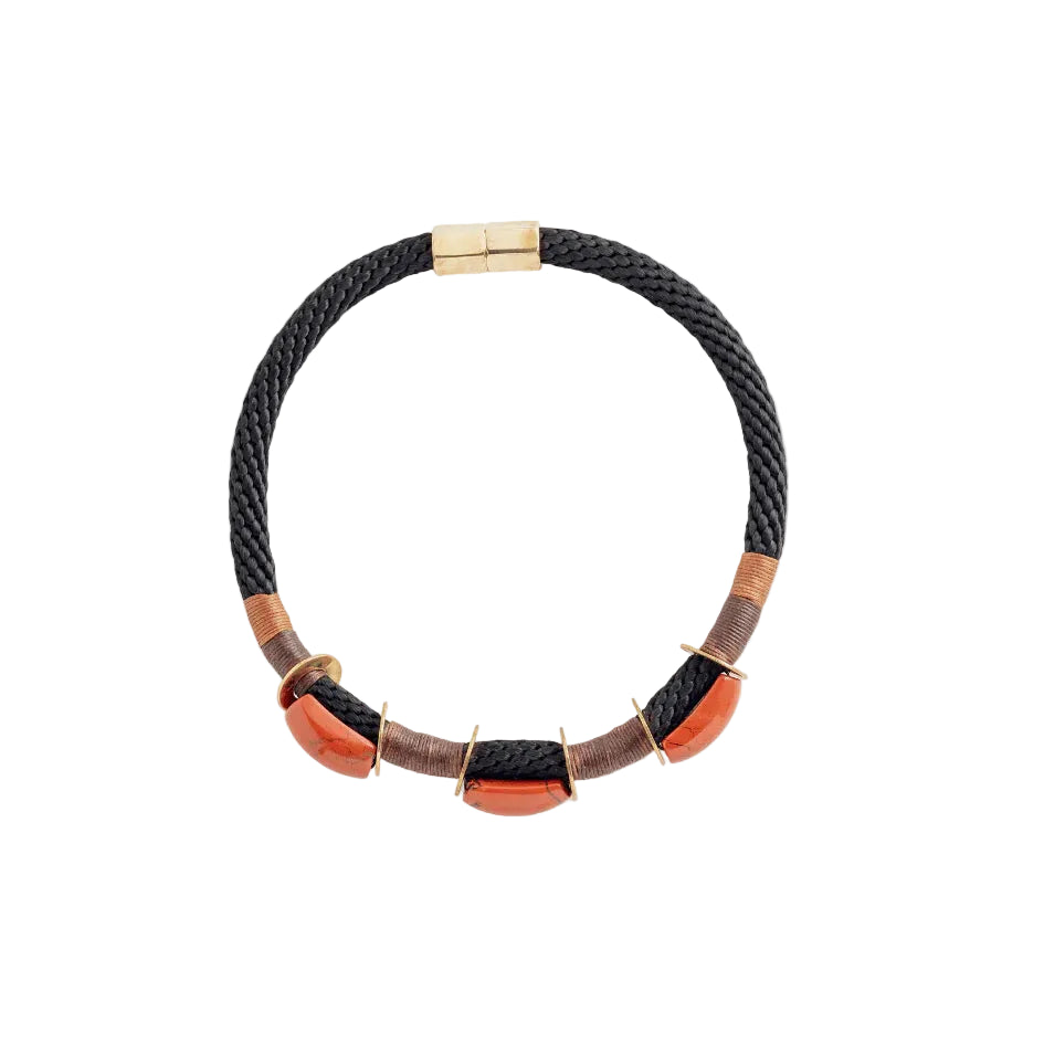 A black braided cord bracelet with three orange-red coral-like bead accents and gold-tone metal hardware, shown on a plain white background.