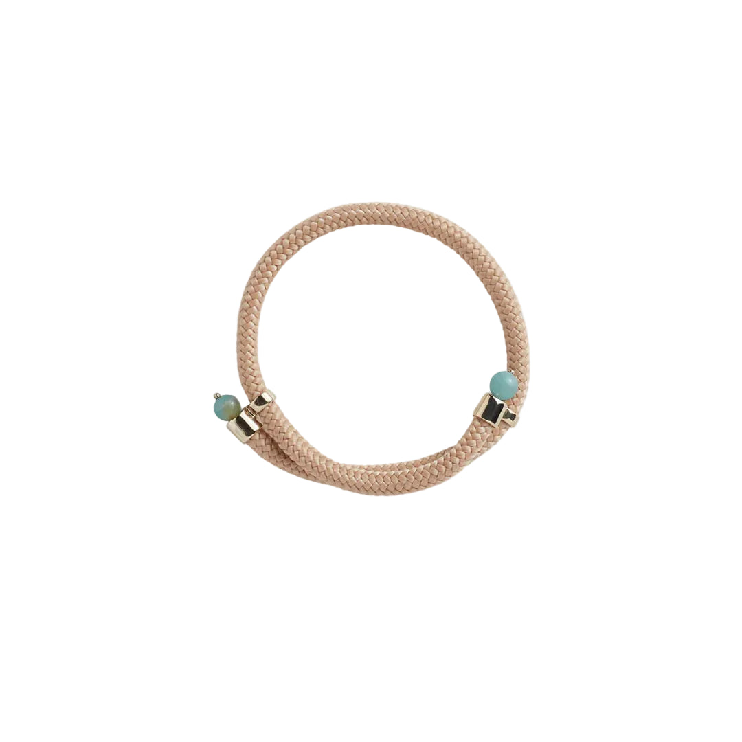 A beige braided cord bracelet with two small turquoise-blue beads and gold-toned metal accents, shown on a plain white background.