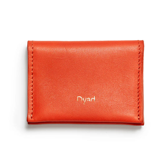 Orange leather wallet with 'Dyad' branding on background