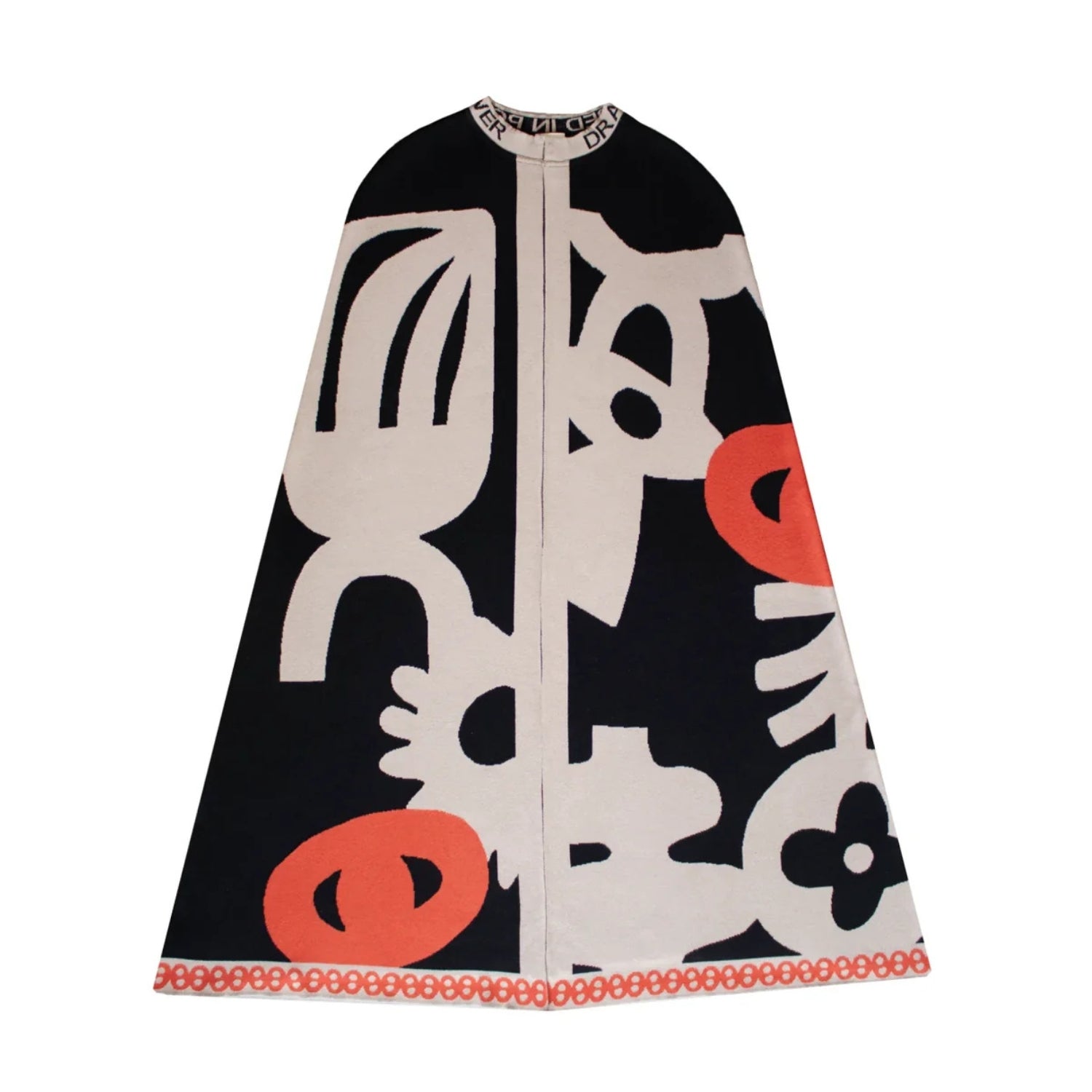 A black and beige jacquard abstract patterned knit cape with coral orange accents.
