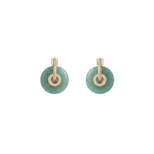 A pair of gold hoop earrings with round green stone disc charms, displayed on a clean white background.