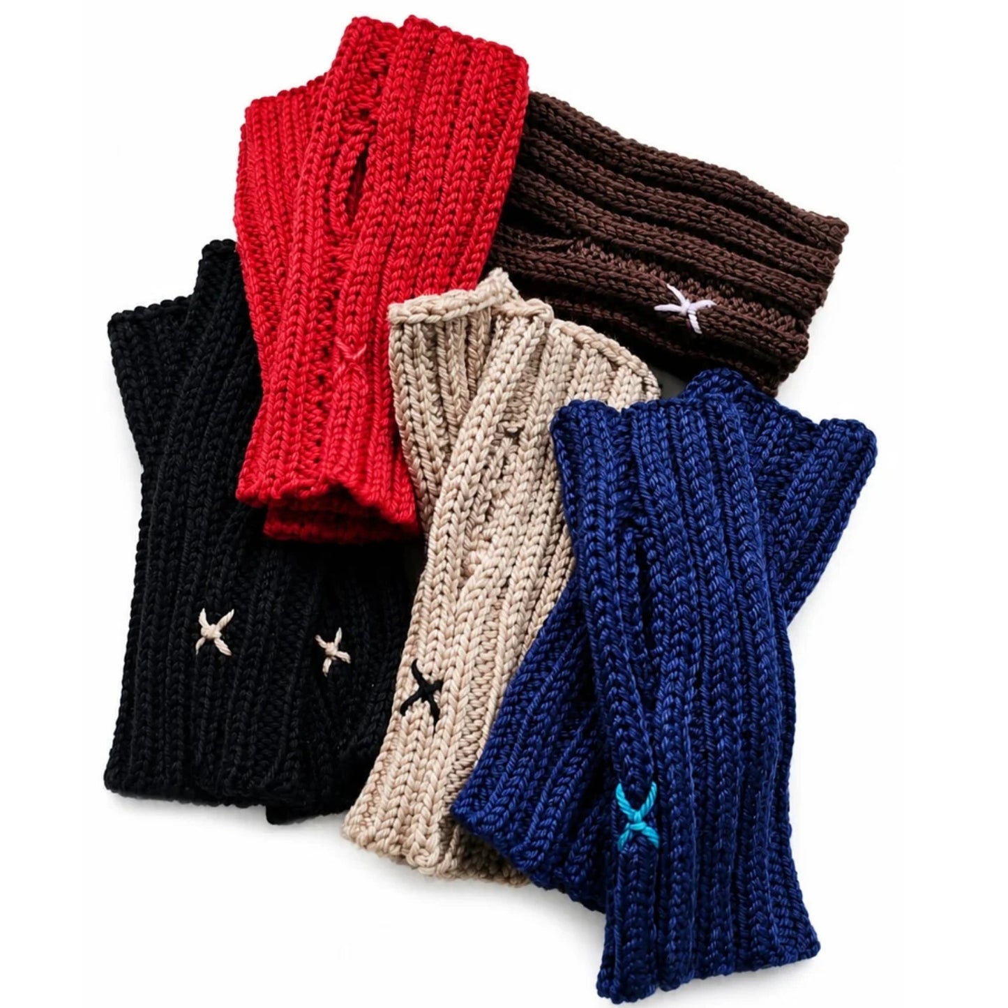 Six pairs of chunky knit fingerless gloves in red, brown, black, beige, navy blue, and royal blue, arranged in a fan shape on a white background. Each pair features a small embroidered cross detail near the cuff.