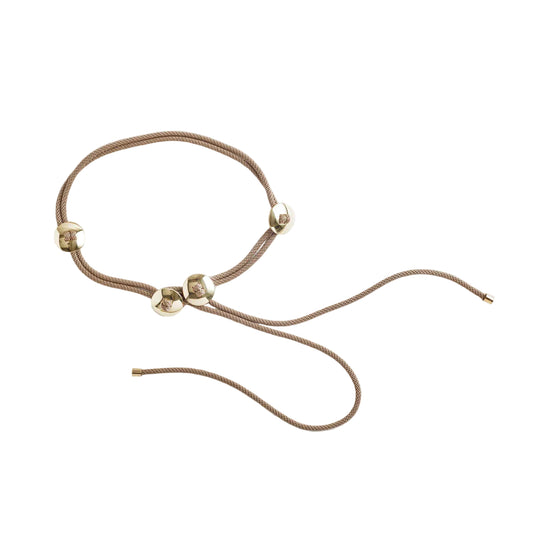 Cord belt with gold beads on a light beige background