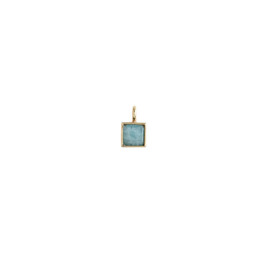 Gold pendant with a blue gemstone on a white background