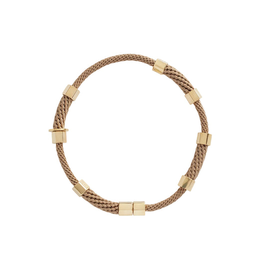 A person wearing a beige choker necklace with brass caps and a textured rope design.